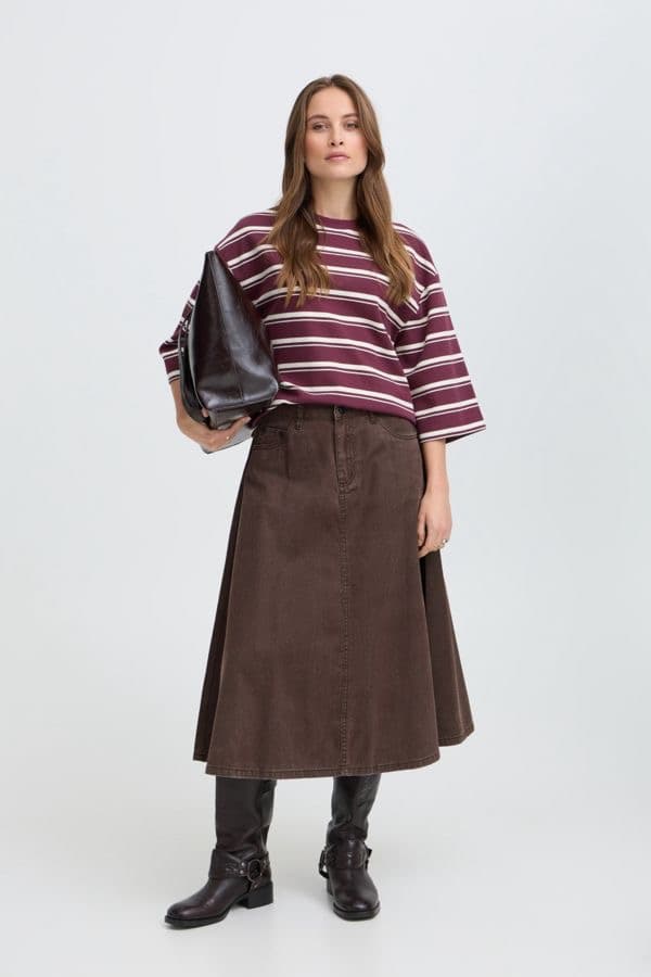 Model in a burgundy and cream striped knit top with a brown midi skirt