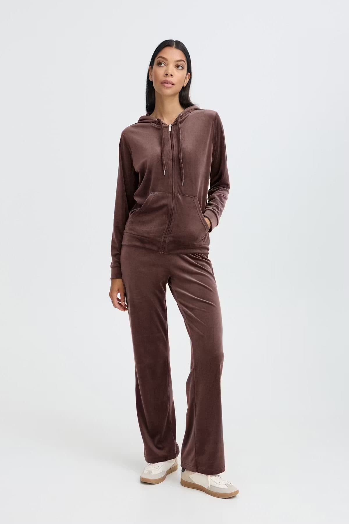 Model in a brown satin-finish loungewear set, studio background