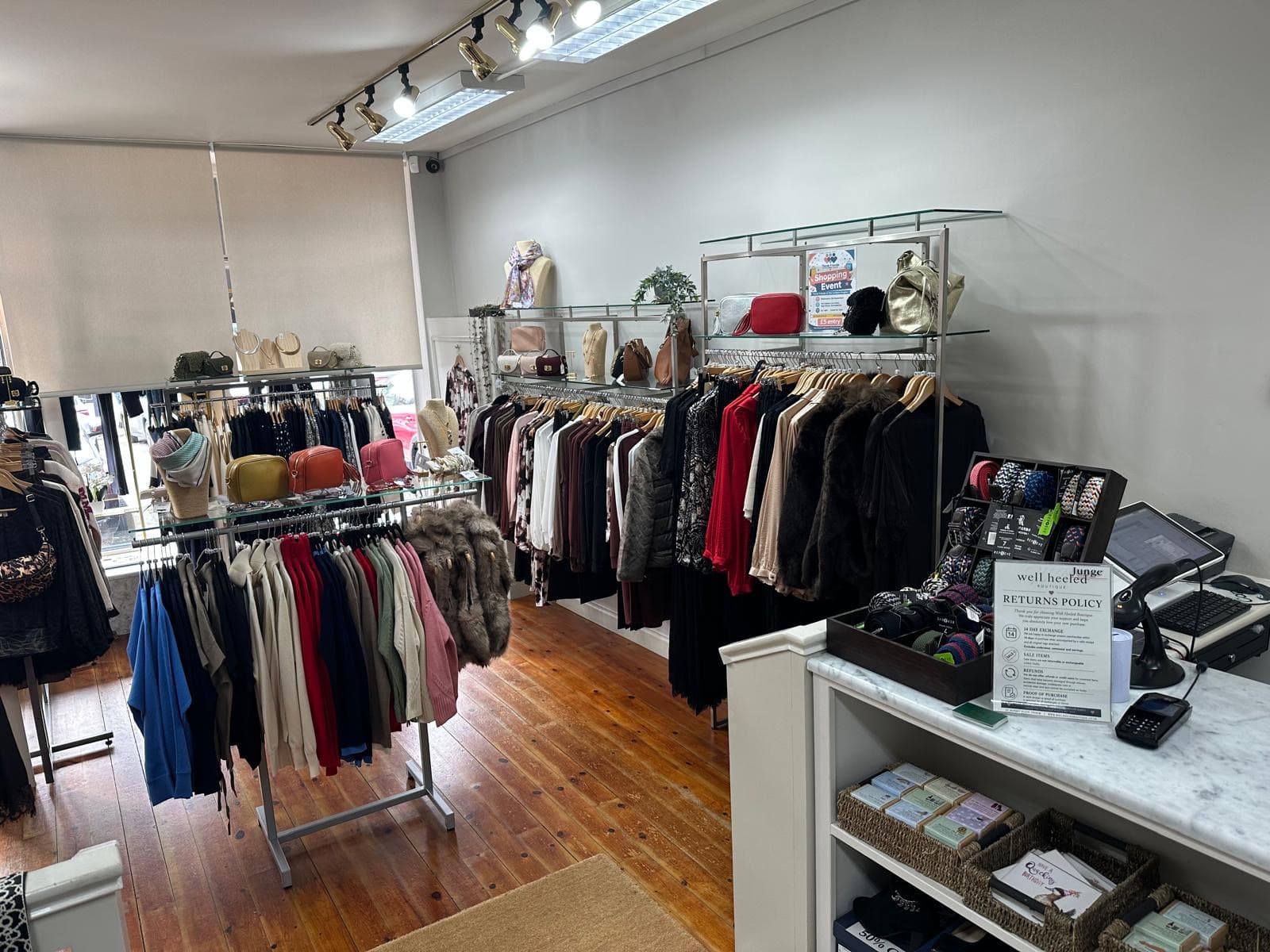 Rails of clothing and the counter inside Well Heeled Boutique, Thirsk